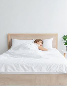 ベッドで眠っている女性 ベッドで眠っている女性の写真