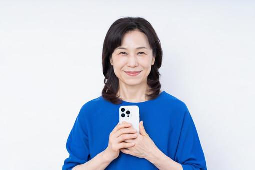 スマホを持つミドルの女性 スマホを持つミドルの女性 スマートフォン,スマホ,携帯の写真素材