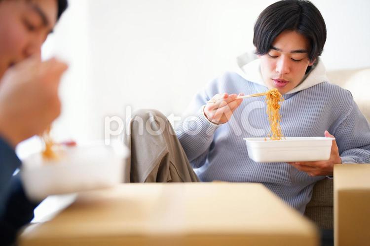 引っ越しの合間にカップ焼きそばを食べる2人の男性 引っ越し,一人暮らし,男性の写真素材