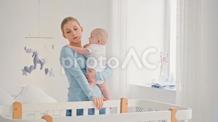 赤ちゃんを抱っこしている疲れ顔の女性 女性,赤ちゃん,かわいいの写真素材