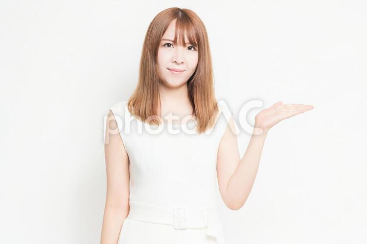 手で案内のジェスチャーをする若い女性 女性,案内,ジェスチャーの写真素材