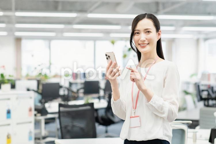 オフィスでスマホを使うビジネスウーマン ビジネスウーマン,若い,女性の写真素材