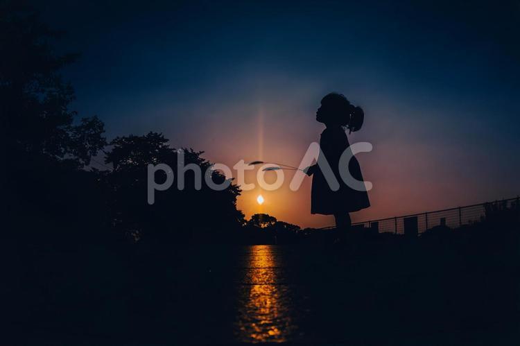 フィルム風の夕暮れ少女のシルエット 子供,女の子,夕焼けの写真素材