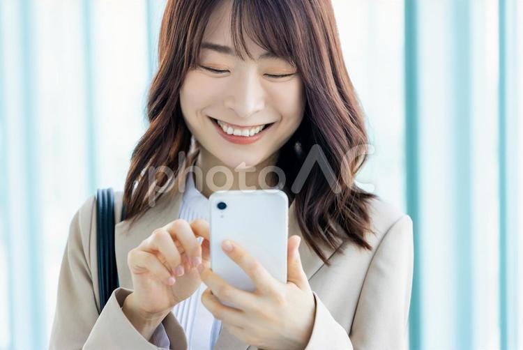 スマホを操作する笑顔のビジネスウーマン 女性,ビジネス,ビジネスウーマンの写真素材