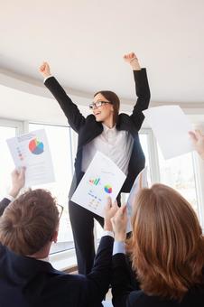両手をあげ横を見る笑顔の女性と書類を持つ人 女性,男女,外国人の写真素材
