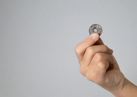 50円玉をつまむ子供の手のクローズアップ 50円玉,硬貨,日本円の写真素材