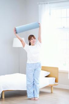 ヨガマットを上に持ち上げる女性 女性,ヨガマット,持ち上げるの写真素材