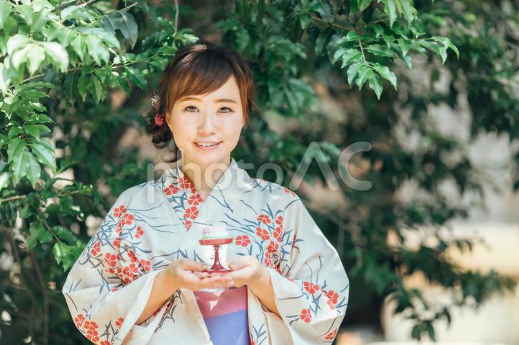 お供物を持つ浴衣姿の女性 お盆,盆菓子,浴衣の写真素材