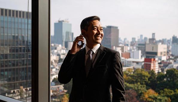 電話するサラリーマン 電話するサラリーマンの写真