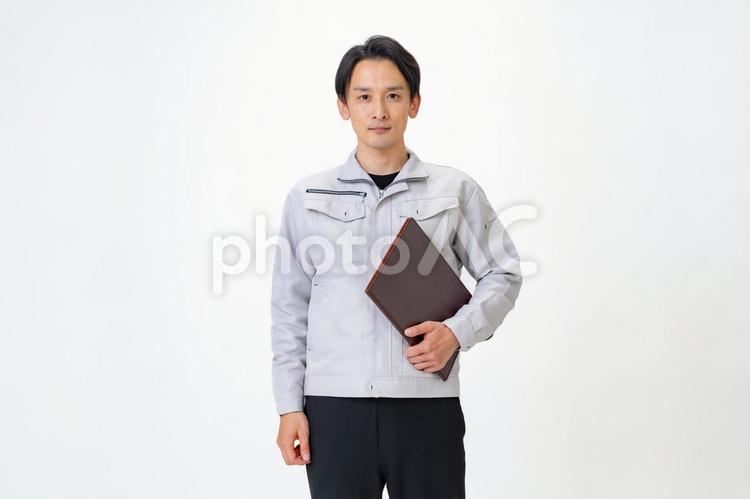 ファイルを持つ作業着を着た男性 日本人,点検,保守点検の写真素材