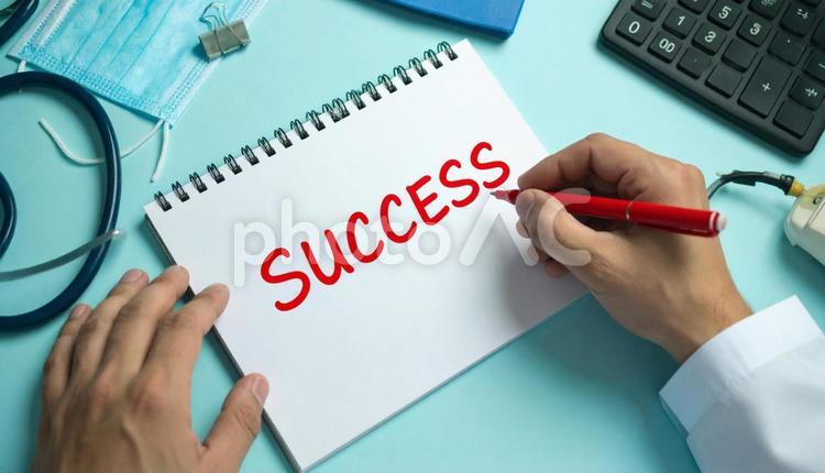「SUCCESS」を書く男性医師の手もと 成功,入院,英単語の写真素材