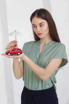 車の模型を持つ女性スタッフ 保険業,事務職,接客業の写真素材
