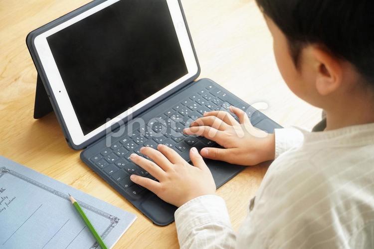 タブレットのキーボードを打つ子供② 引き タブレット,学習,子供の写真素材