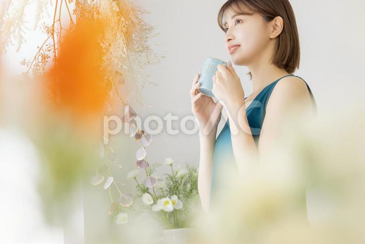 コーヒーを飲む若い女性　ライフスタイル 女性,花,紅茶の写真素材