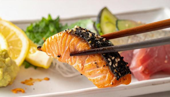 七輪で焼いている焼き鮭を箸でとる 七輪で焼いている焼き鮭を箸でとるの写真