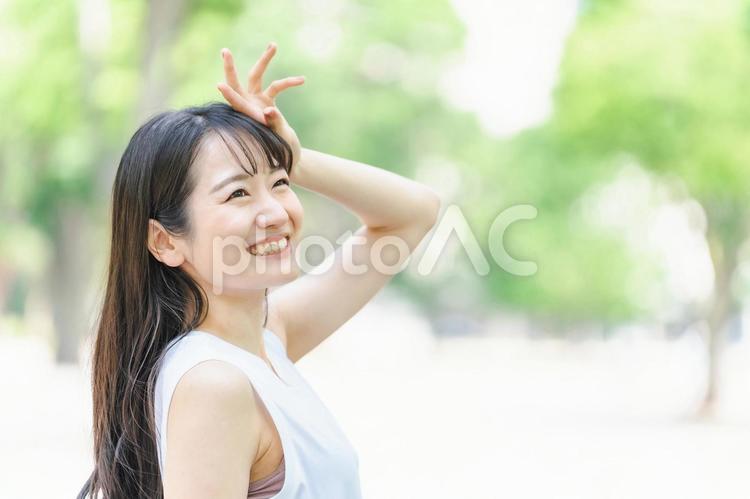 新緑の中で日光を浴びる日本人女性 新緑の中で日光を浴びる日本人女性 日焼け止め,紫外線対策,女性の写真素材