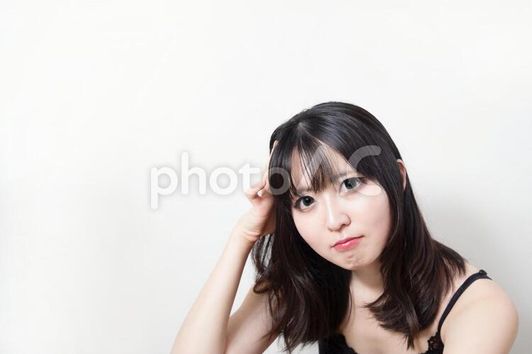 何かを考えて首を傾げる女性 人物,女性,悲しいの写真素材