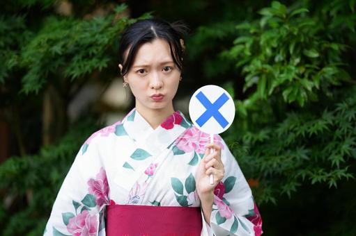 浴衣姿の女性がバツカードをあげる 女性,浴衣,バツの写真素材