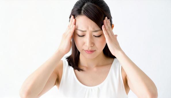 こめかみを押さえる若い女性のストレス表情 こめかみを押さえる若い女性のストレス表情の写真