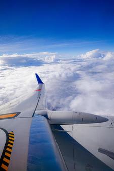 飛行機の翼とどこまでも続く雲海_縦 飛行機の翼とどこまでも続く雲海_縦 空,雲,雲海の写真素材