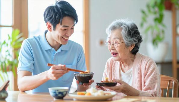 食事介助をする男性介護士と高齢女性 食事介助をする男性介護士と高齢女性の写真