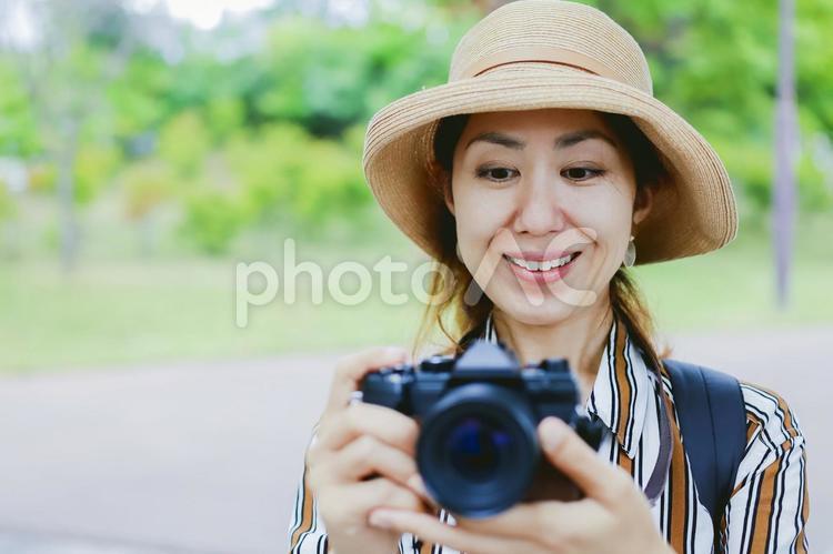 カメラを持って微笑む女性 カメラ,一眼レフ,一眼レフカメラの写真素材