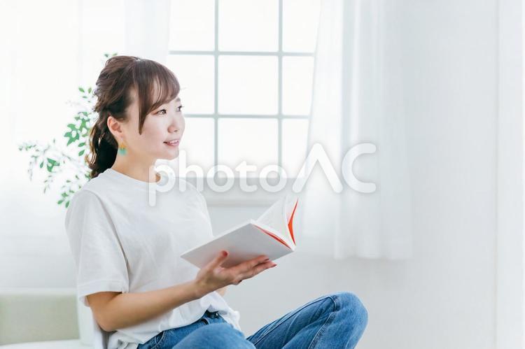 家のソファで本を読む日本人女性（読書） 勉強,読書,女性の写真素材