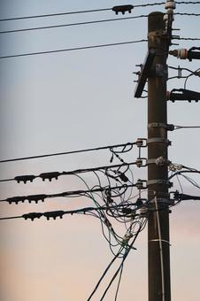 夕焼けに染まる空と絡み合う電柱の配線 電柱,電線,配線の写真素材