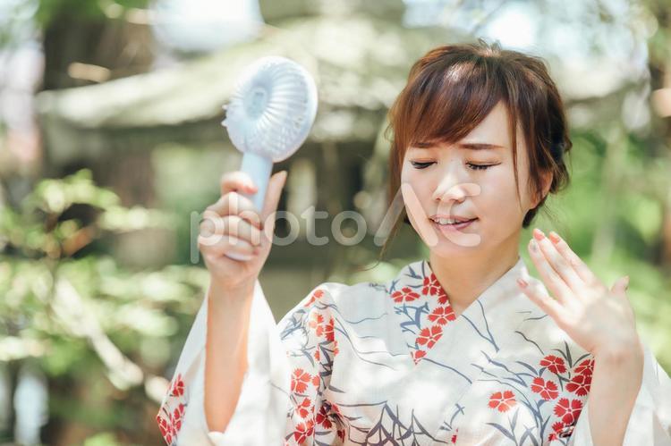 扇風機を持つ浴衣姿の女性 浴衣,暑い,ハンディファンの写真素材