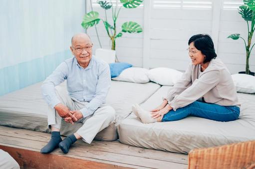 ベッドルームでくつろぐ高齢の夫婦 日本人,部屋,介護の写真素材