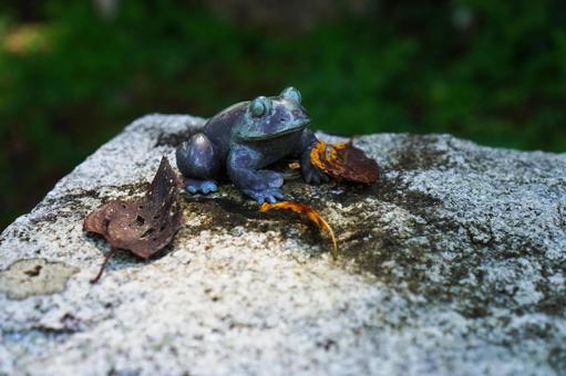 石の上のカエルの置き物と落ち葉 石の上のカエルの置き物と落ち葉 カエルの置き物,カエル,置き物の写真素材