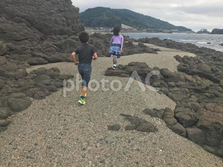 海辺の磯場を走る子ども 海辺,磯場,海の写真素材