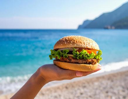 砂浜で持つハンバーガー 砂浜で持つハンバーガーの写真