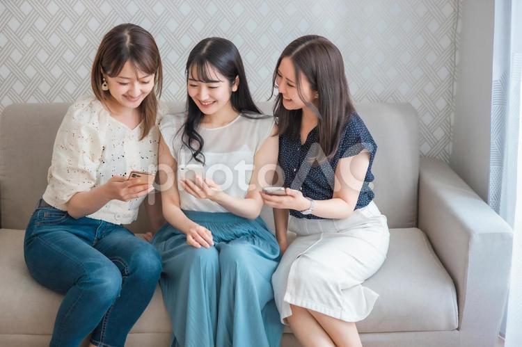 スマホを使う女性たち（爆笑） スマートフォン,スマホ,女子会の写真素材