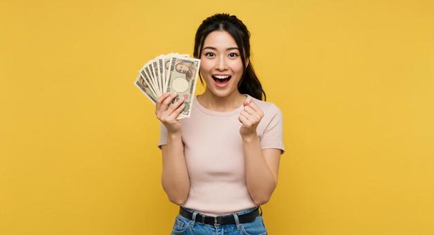 お札を手にして喜ぶ女性 お札を手にして喜ぶ女性の写真