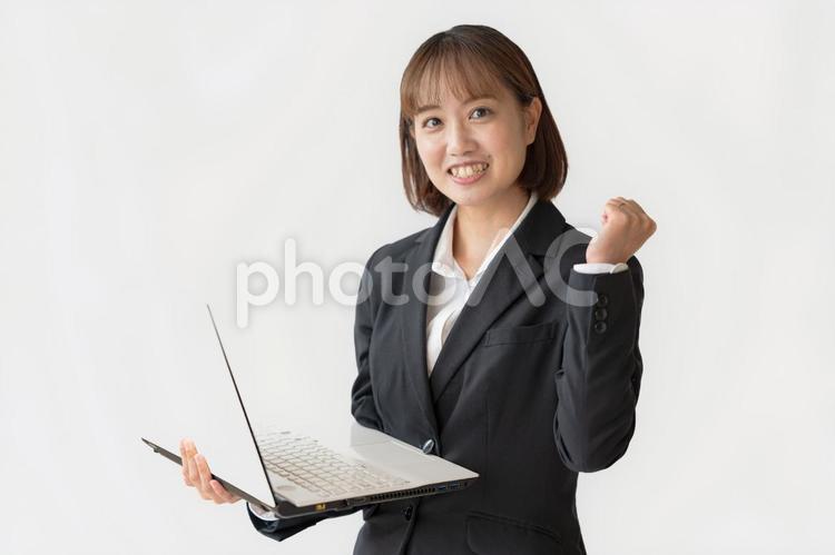 ガッツポーズでPCを持つビジネスウーマン パソコン,不動産,転職の写真素材