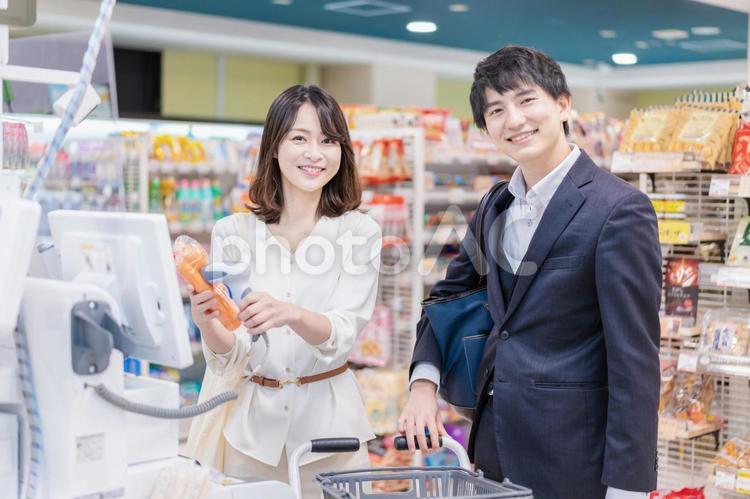 スーパーでセルフレジを使う若い夫婦 日本人,フレッシュ,景気の写真素材