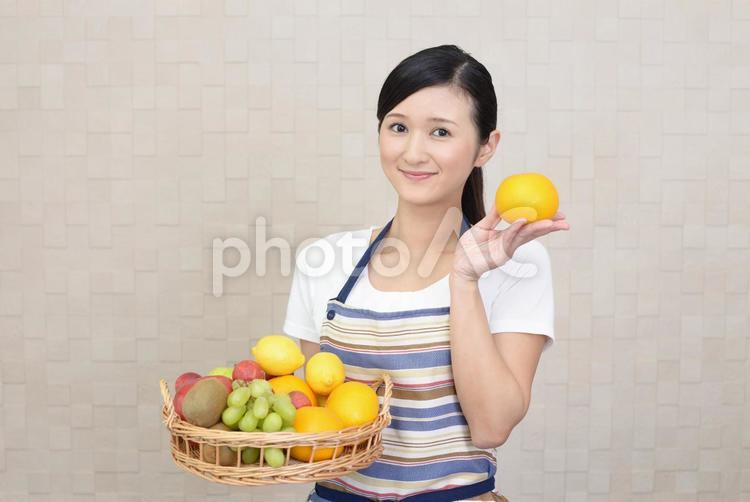 果物を持つ笑顔の女性 女性,女,オレンジの写真素材