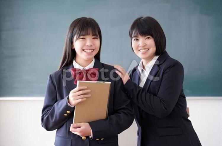 教室で笑顔で立つ日本人女子中学生と教師 中学生,女子,日本人の写真素材