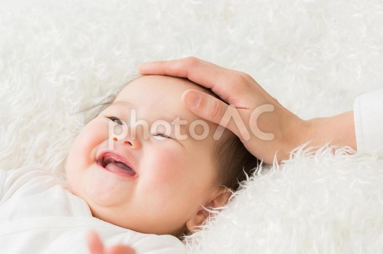 女性に撫でられる赤ちゃん（笑顔） 赤ちゃん,なでる,母親の写真素材