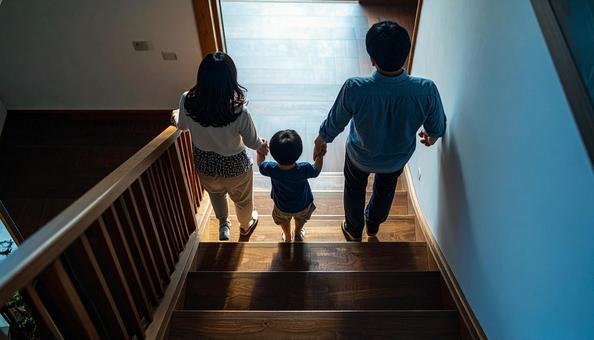 階段を下りるのが楽しい子供と見守る両親 階段を下りるのが楽しい子供と見守る両親の写真