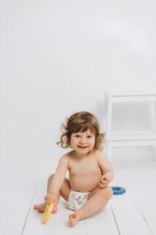 笑ってお座りをするオムツの子供 笑ってお座りをするオムツの子供 赤ちゃん,かわいい,お座りの写真素材