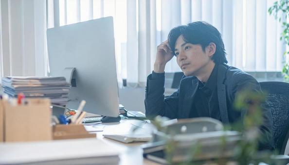 PC作業をするビジネスマン PC作業をするビジネスマンの写真