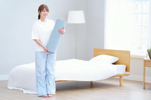 ヨガマットを持ち立つ女性 女性,ヨガマット,持つの写真素材