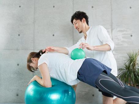 Japanese woman receiving plank instruction from a personal trainer Japanese woman receiving plank instruction from a personal trainer