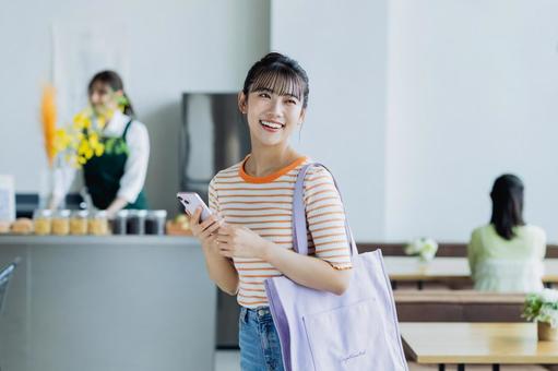 カフェに来店する若い女性 カフェに来店する若い女性 カフェ,女性,笑顔の写真素材
