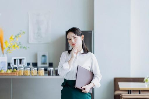 悩むカフェで働く若い女性 悩むカフェで働く若い女性 悩む,飲食店,カフェの写真素材