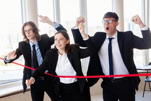 ガッツポーズの外国人3人と赤いテープ 男女,外国人,ビジネスの写真素材