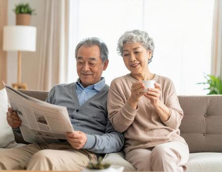 リビングでくつろぐ老後の老夫婦の写真