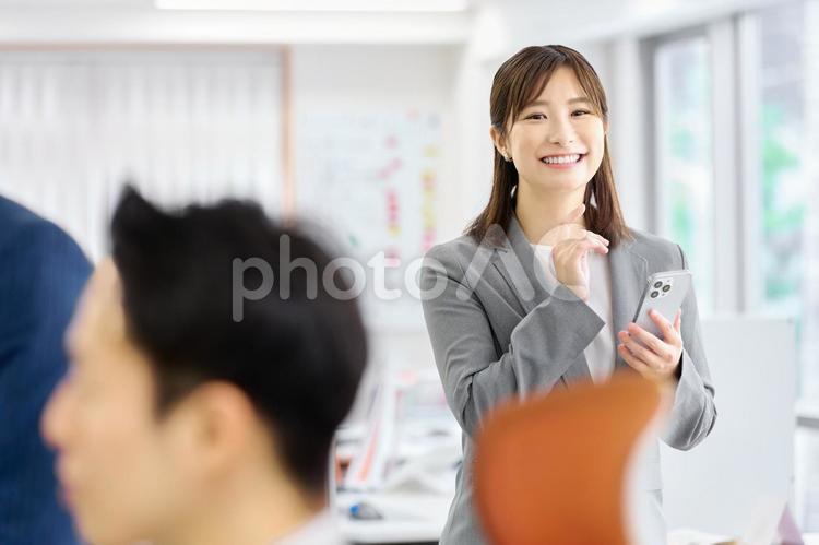 スマホを持つビジネスウーマン　会社 ビジネスウーマン,笑顔,スマホの写真素材